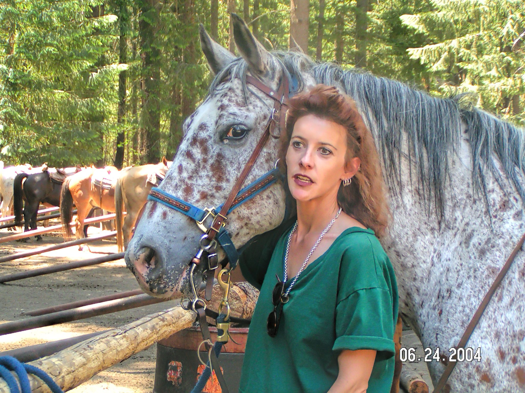 Photo of author standing next to an appaloosa horse.