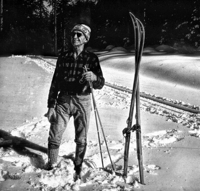 black and white photo of al hobart standing in the snow with his cross country skiis planted vertically next to him.