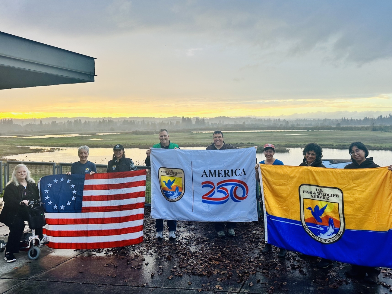 Photo of fish and wildlife employees holding up various flags.
