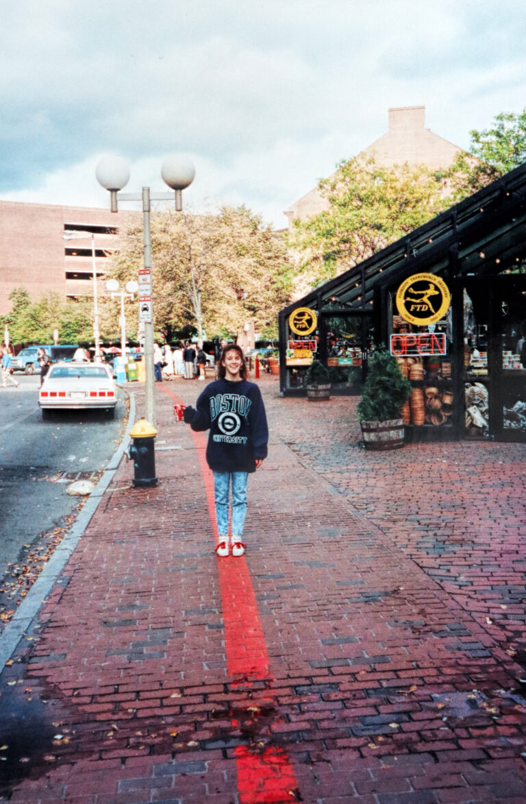 photo of author standing on the red line of the Boston Freedom Trail wearing a Boston University sweatshirt and holding up a can of coke.