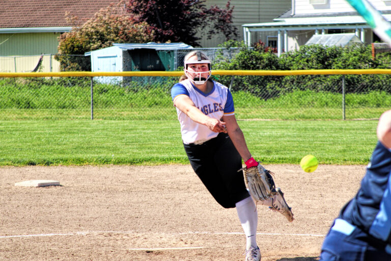 photo of a high school softball player who has just pitched the ball.