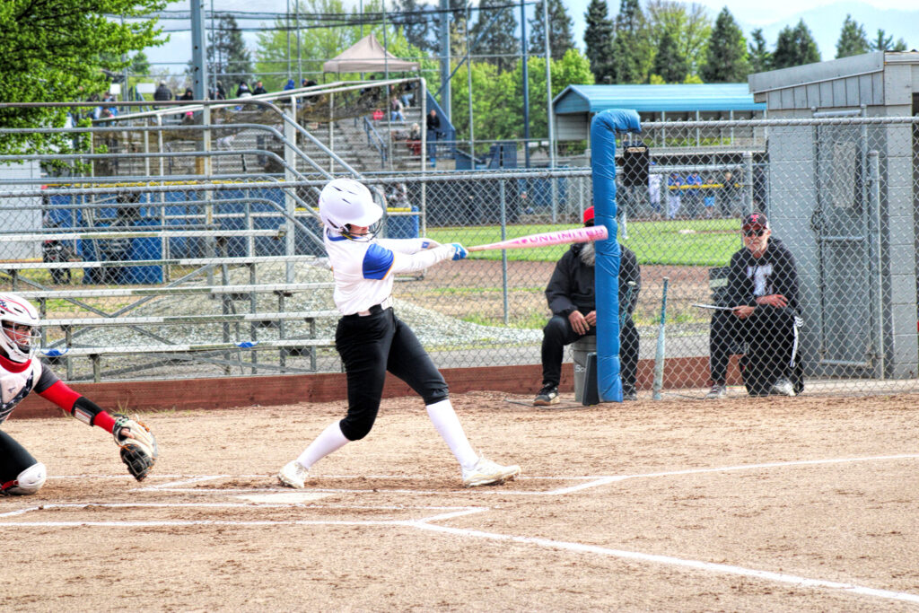 photo of a high school soffball player who has just hit the ball.