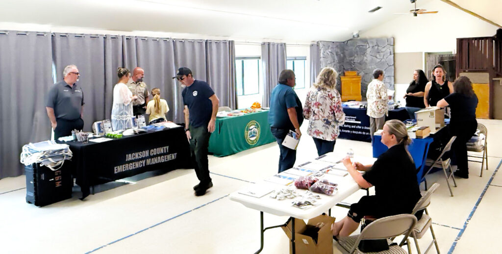 photo of an emergency management open house with various agency tables and citizens.