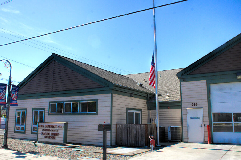 photo of firehouse with flag at half mast.