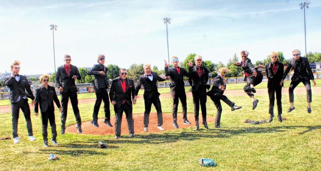 photo of 12 baseball players in their prom suits in mid air as they jump.