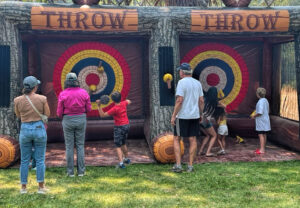 photo of kids and adults at a velcro ax throwing game.