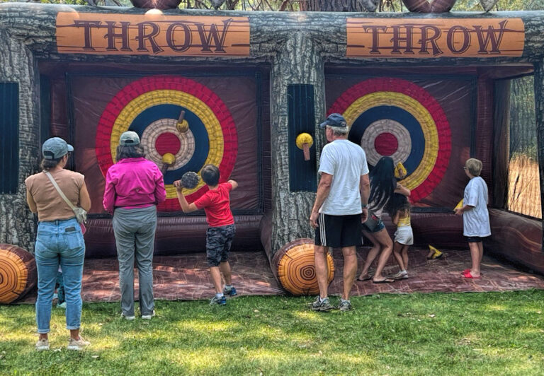 photo of kids and adults at a velcro ax throwing game.