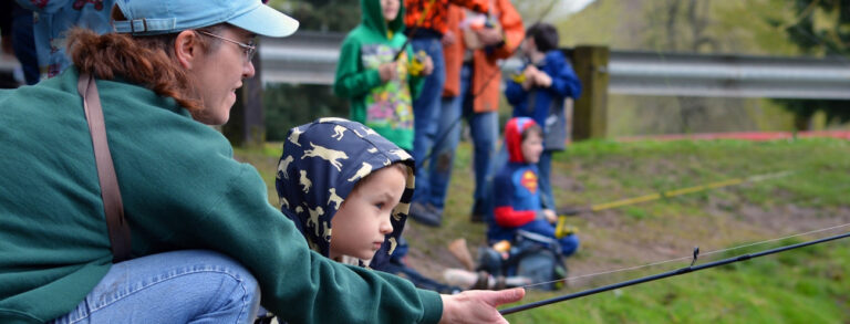 photo of adults and young children fishing.