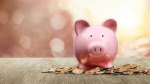 photo of a piggy bank placed on a pile of pennies.