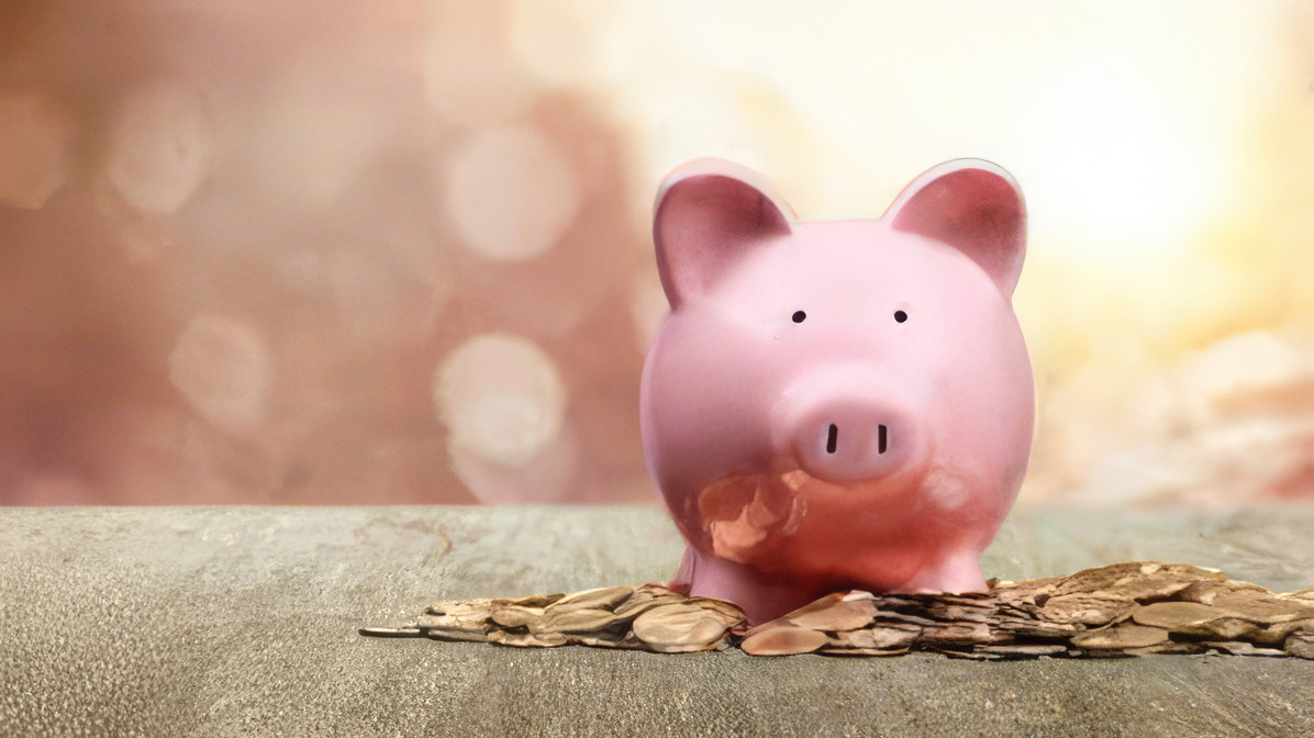 photo of a piggy bank placed on a pile of pennies.