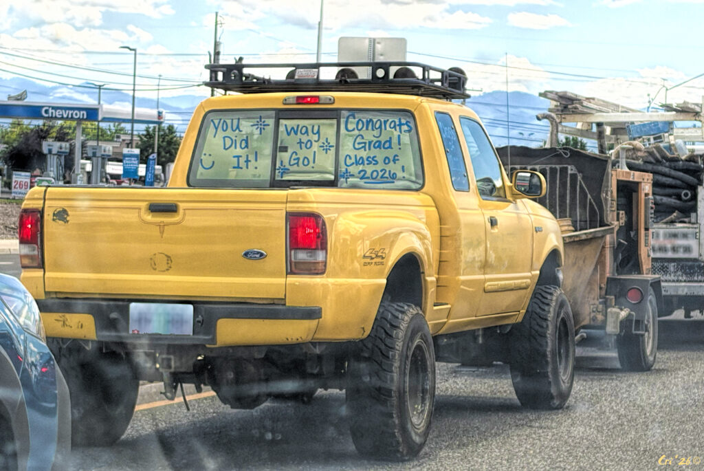 photo of a yellow pickup truck with "you did it" "way to go" and "Congrats grad! class of 2026" painted on the back windows of the cab.