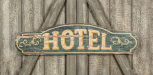 A vintage "hotel" sign on what looks like a barn door.