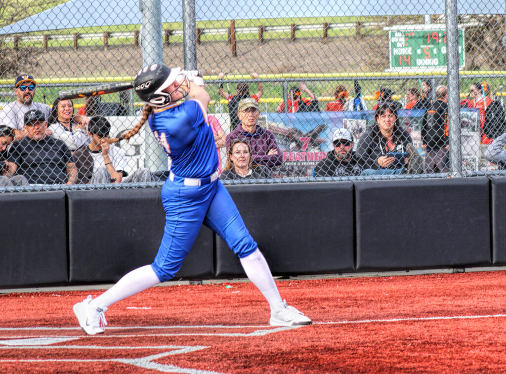 photo of a high school softball player just after she hit the ball.