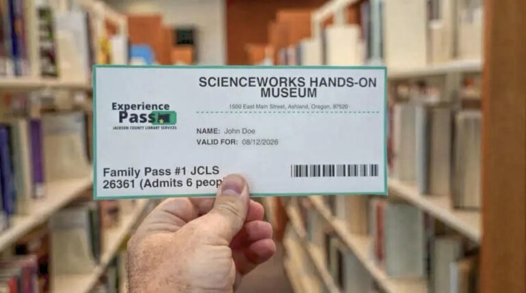 Photo of a hand holding a library experience pass.