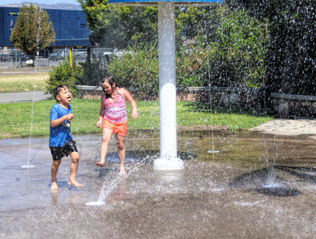 photo of two children playing in a splash park.
