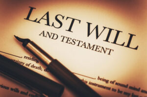 photo of a will with a fountain pen resting on it.