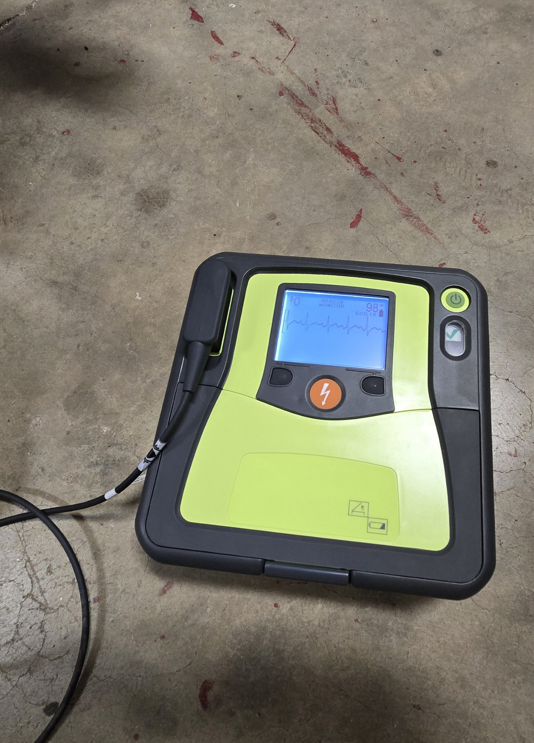 photo of a defibrillator on a concrete floor.
