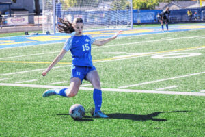 photo of a girl about to kick a soccer ball during a high school soccer game.
