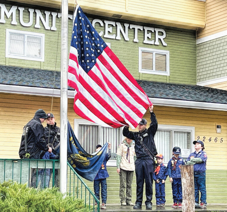photo of boy scouts raising an american flag.