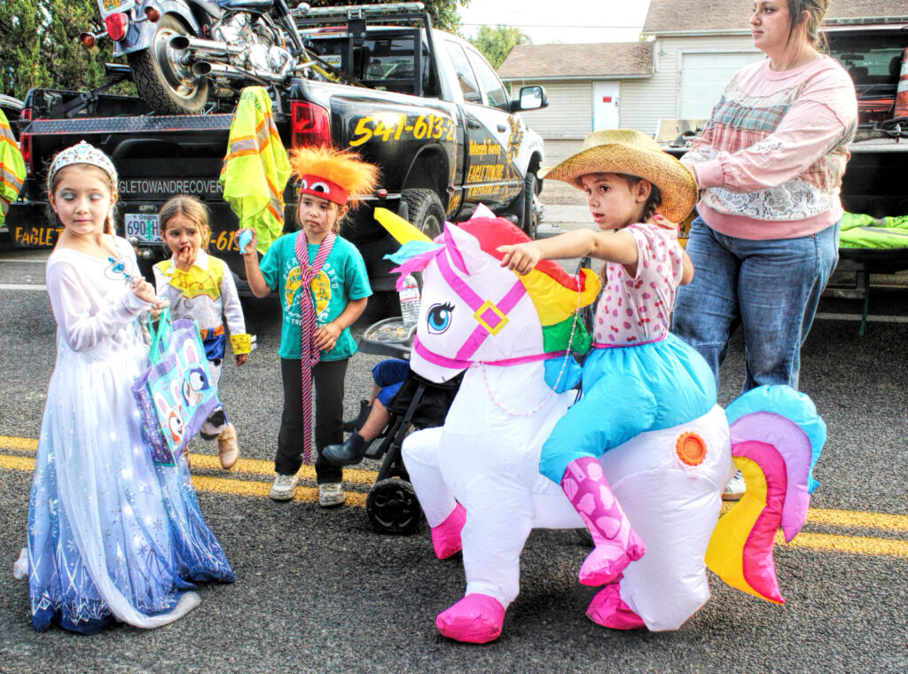 photo of four children in halloween costumes at a street fair.